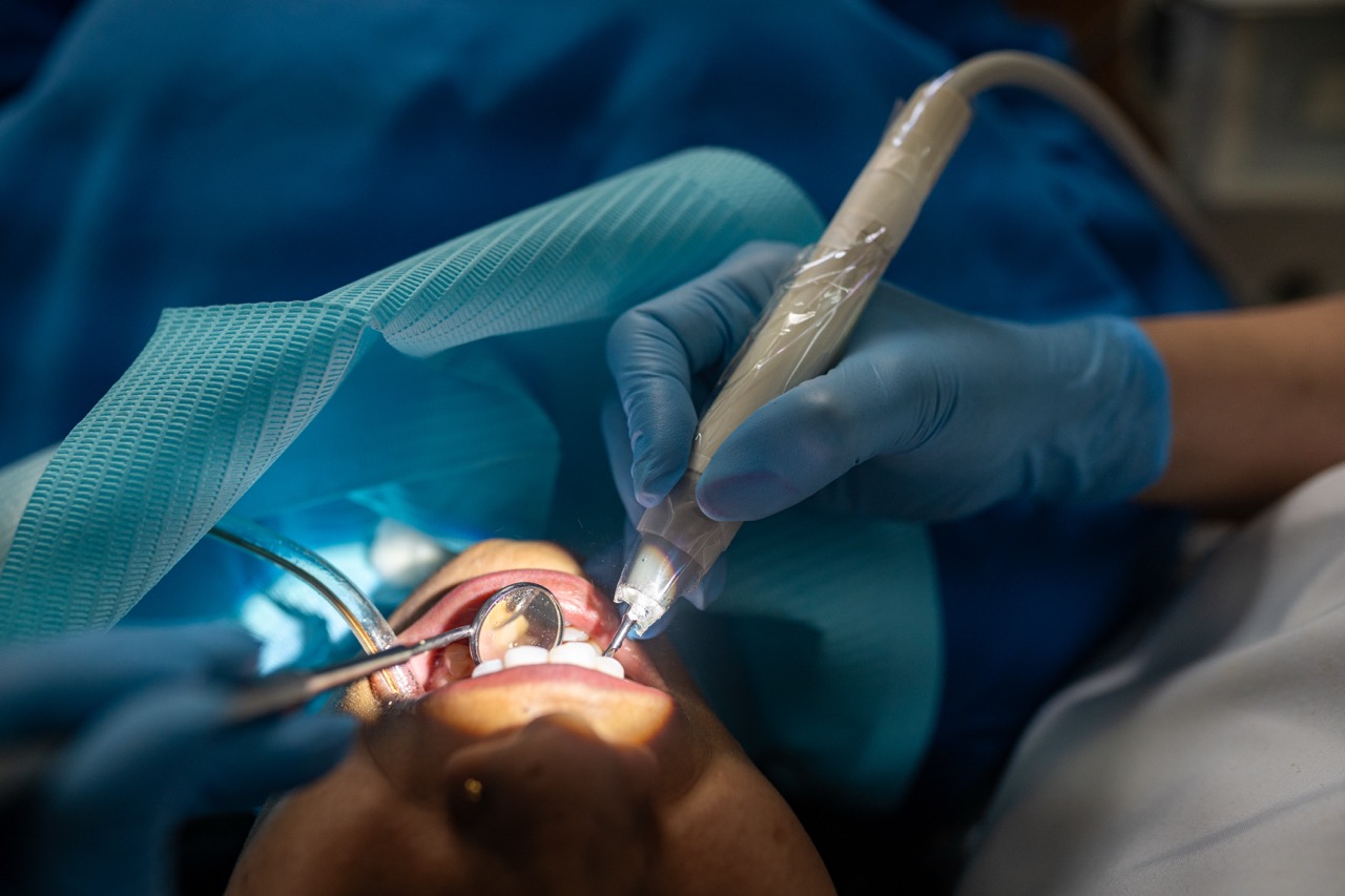 Close-up of hands of dentist using drill on a tooth for a filling on a young woman patient